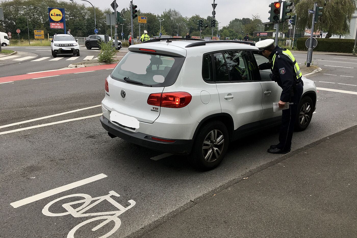 2024_09_16_Foto_EMW_Aufstellflaeche.jpg Bild 1: PHK Heiko Mann, Bezirksdienst Wermelskirchen, informiert Autofahrer und überreicht Info-Flyer